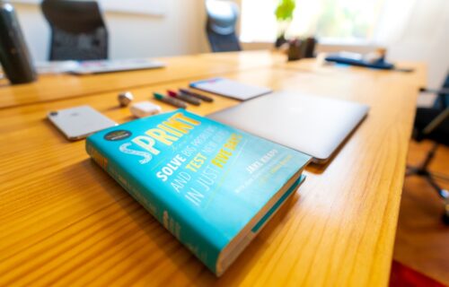 SPAC special purpose acquisition - blue and green book on brown wooden table