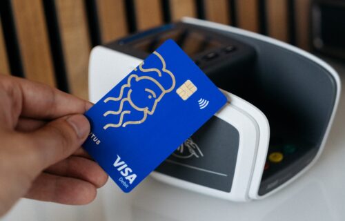 visa money movement - a person is holding a blue credit card