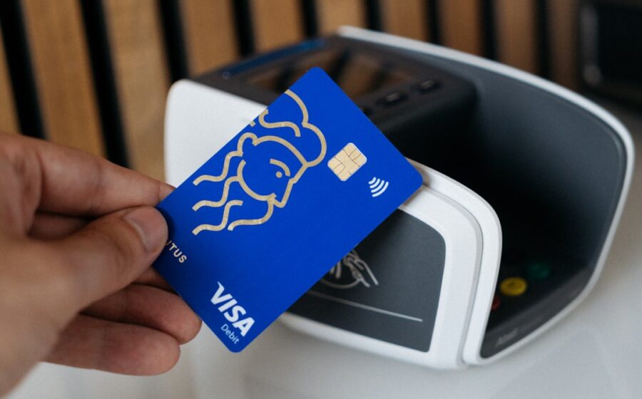 visa money movement - a person is holding a blue credit card