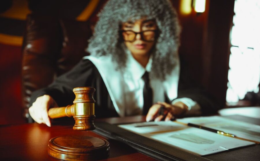 zelle fraud lawsuit - A judge in a courtroom holding a gavel, focused on legal documents.