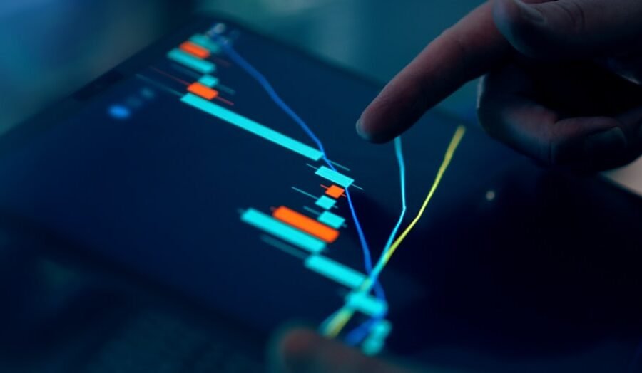 invest in ai - Fingers interacting with a stock market graph on a tablet.