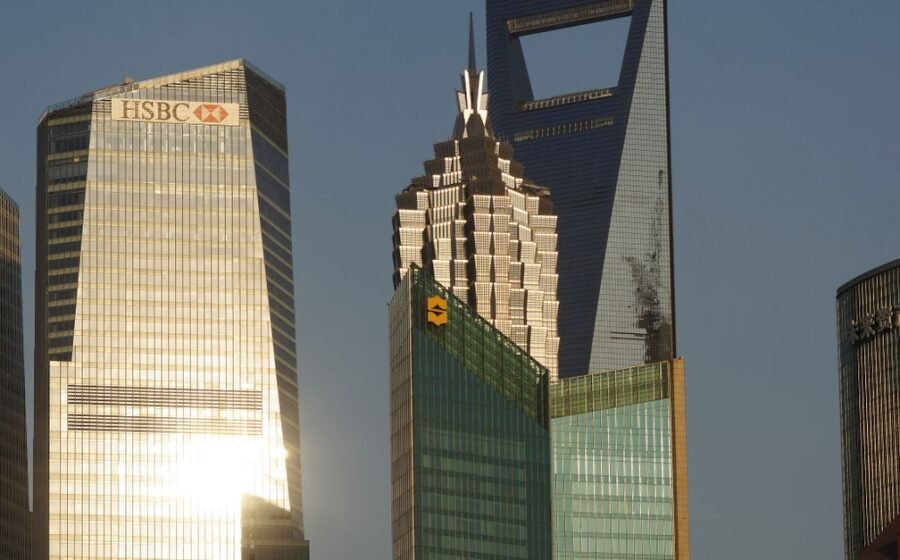 hsbc ai investment - Glowing skyscrapers in Shanghai's financial district reflecting evening light.