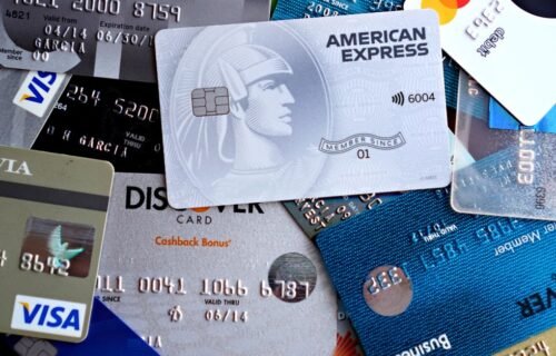 ai agent payments - Close-up image of various credit and debit cards including Visa, MasterCard, American Express, and Discov