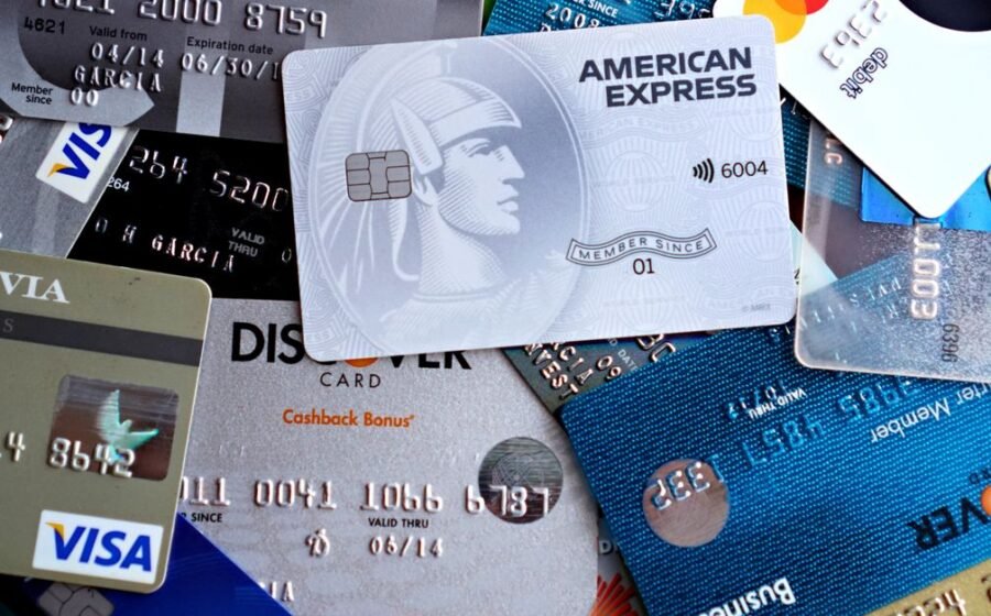 ai agent payments - Close-up image of various credit and debit cards including Visa, MasterCard, American Express, and Discov