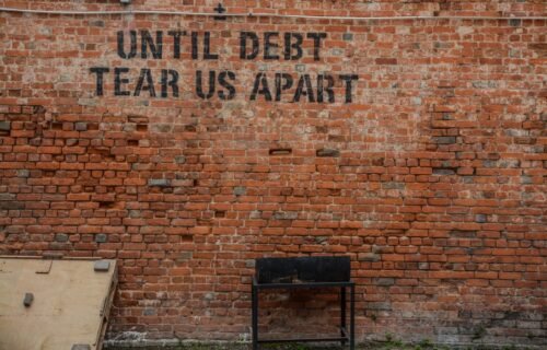 ai build-out - Until debt tear us apart printed red brick wall at daytime