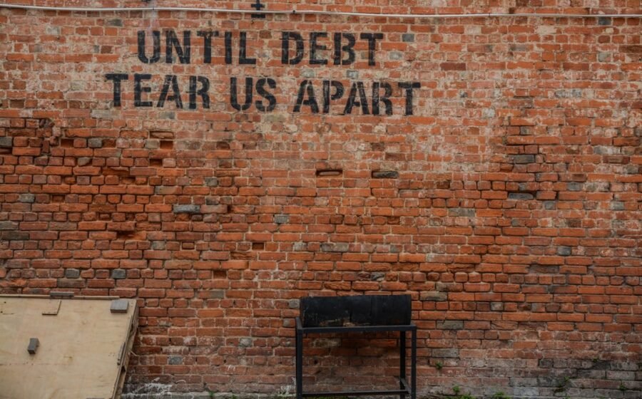 ai build-out - Until debt tear us apart printed red brick wall at daytime