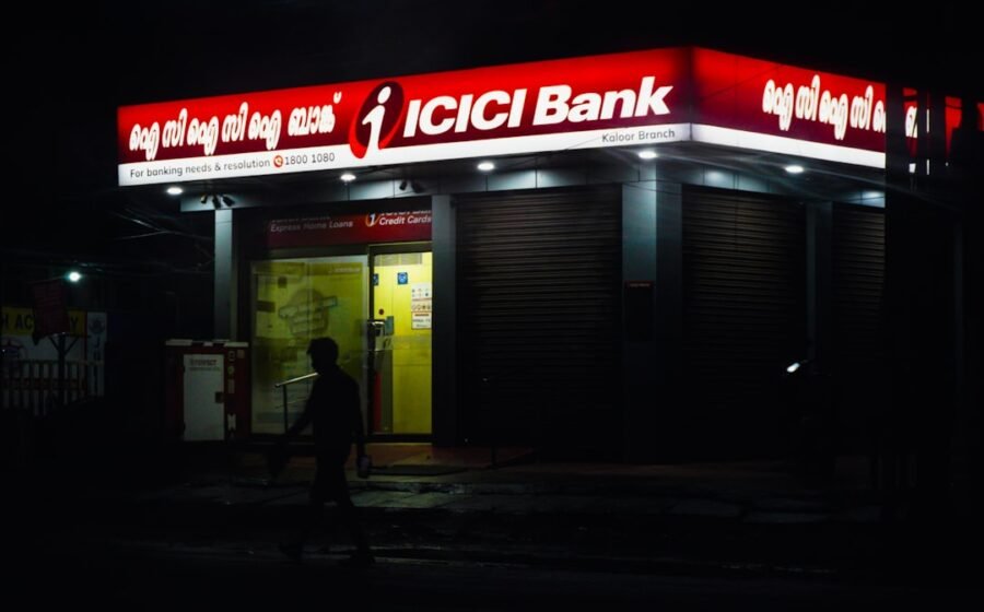 banks add branches - Icici bank building illuminated at night, person walking nearby