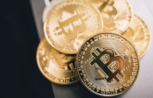 mirae crypto plans - Close-up of golden Bitcoin coins on a laptop keyboard, symbolizing cryptocurrency investment.
