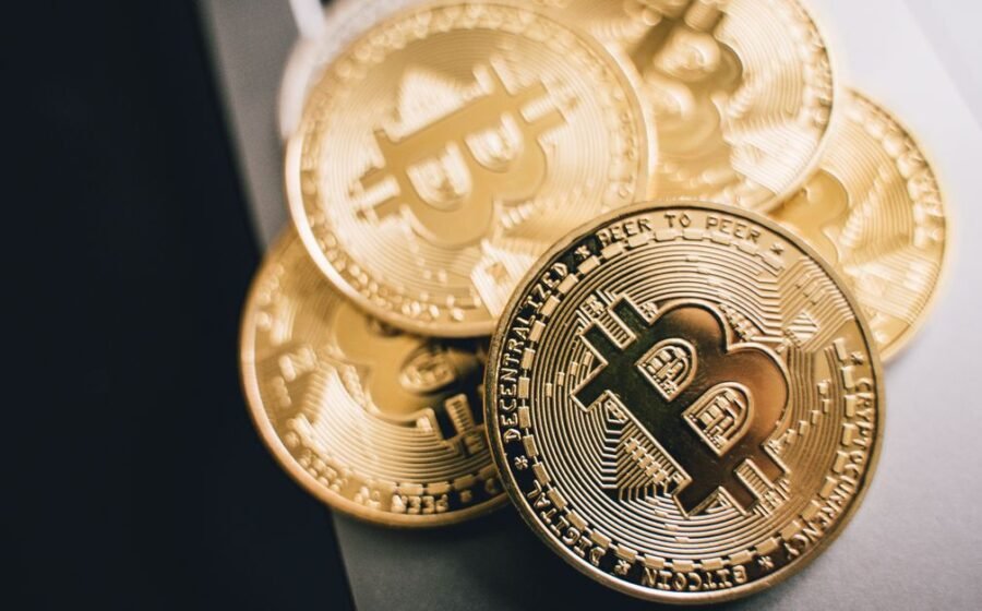 mirae crypto plans - Close-up of golden Bitcoin coins on a laptop keyboard, symbolizing cryptocurrency investment.