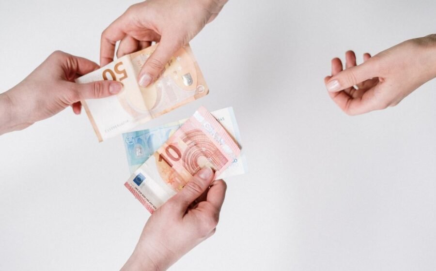 digital euro privacy - Close-up of hands exchanging euro banknotes, symbolizing currency trade and financial transactions.