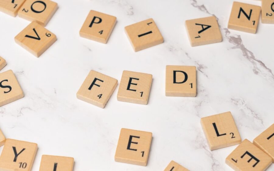 fdic consent order - Scrabble tiles arranged to spell 'FED' on a marble surface, symbolizing finance.