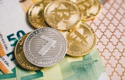 stablecoin kyc debate - Close-up of digital cryptocurrency coins and Euro banknotes, representing modern finance.