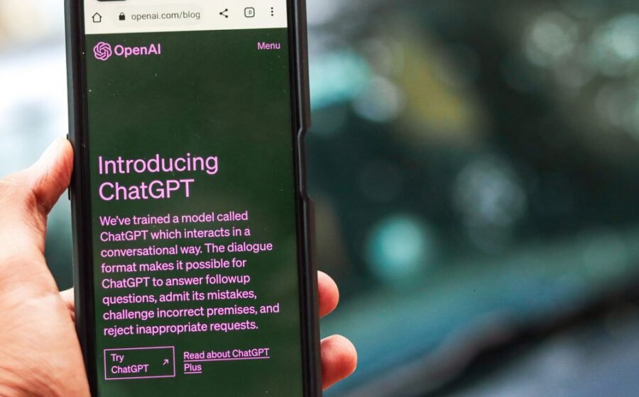 openai ipo 2027 - Close-up of a smartphone showing ChatGPT details on the OpenAI website, held by a person.