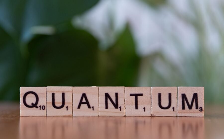 quantum computing growth - Creative depiction of 'quantum' using wooden letter blocks on a blurred natural background.