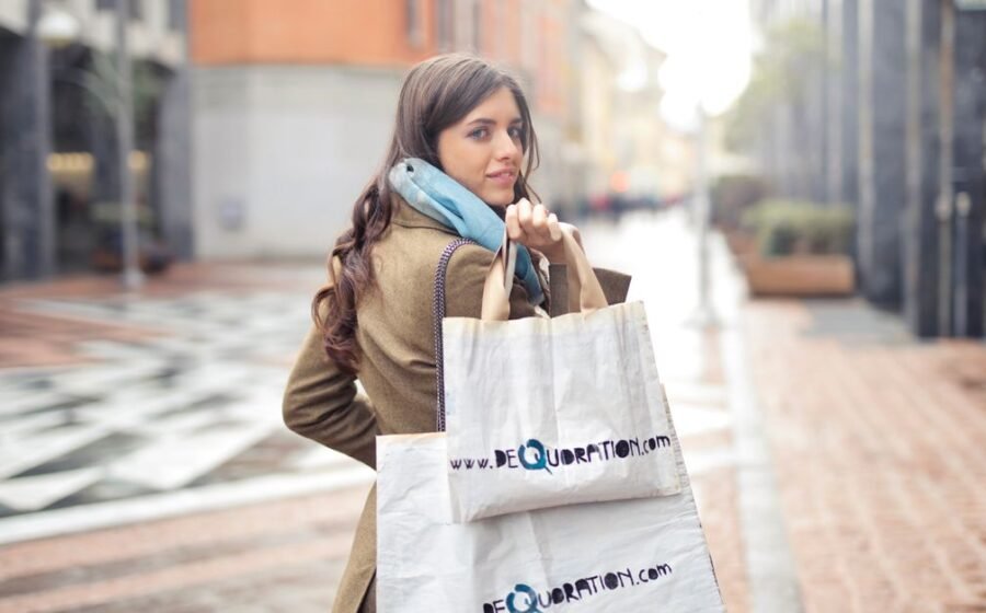 qvc group bankruptcy - A fashionable woman shopping with bags in an urban street, exuding winter fashion style.