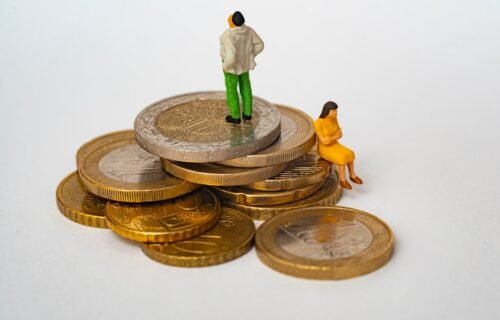roth conversions - A miniature man and woman on a stack of gold and silver coins