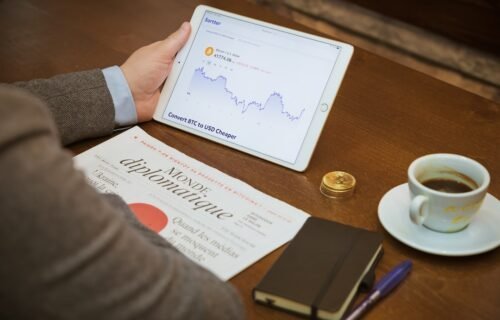 SME financing options - a person sitting at a table with a tablet and a cup of coffee