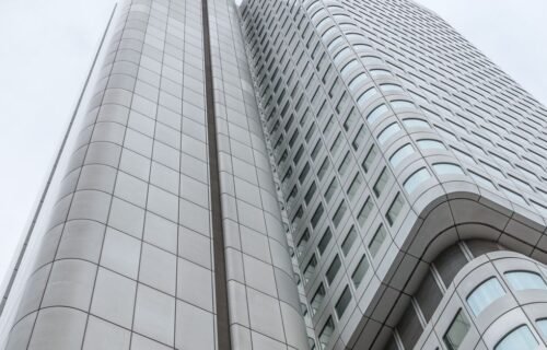 ubs aml failures - Low angle view of a futuristic skyscraper in Frankfurt, Germany, against a cloudy sky.