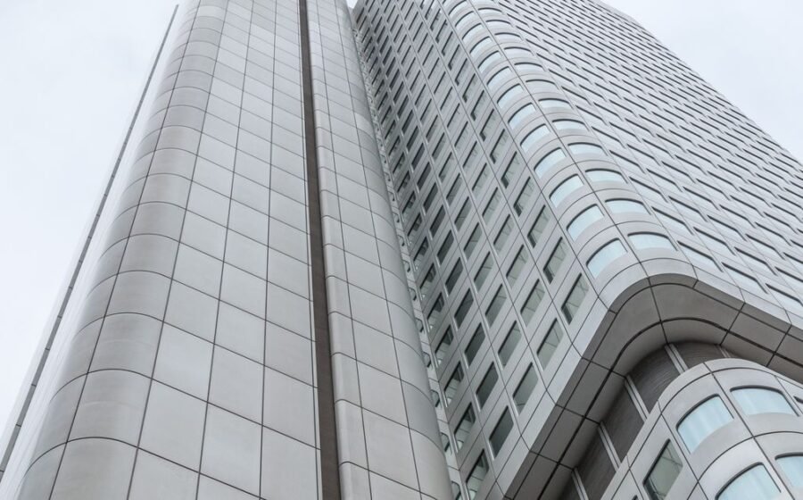 ubs aml failures - Low angle view of a futuristic skyscraper in Frankfurt, Germany, against a cloudy sky.