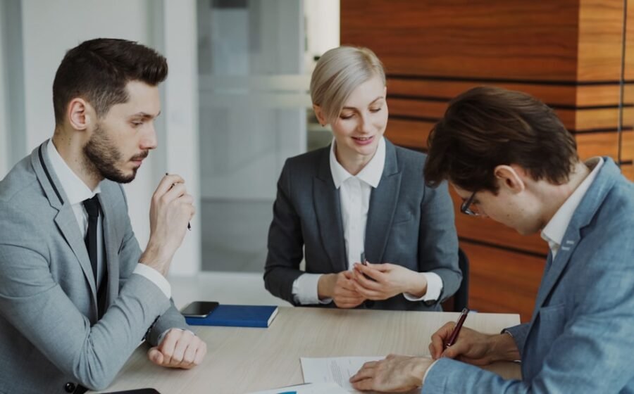 Business people signing a contract at a table.