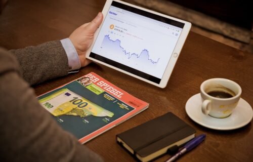 correspondent banking - a person sitting at a table with a tablet and a cup of coffee