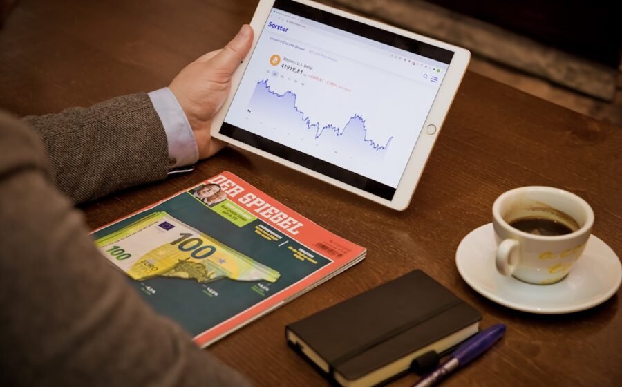 correspondent banking - a person sitting at a table with a tablet and a cup of coffee