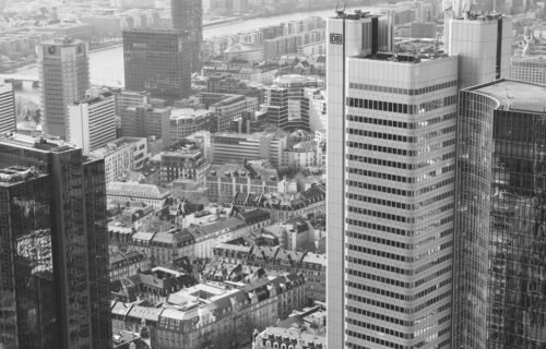 terrapay deutsche bank - A stunning aerial view of Frankfurt am Main's modern high-rise skyline in black and white.