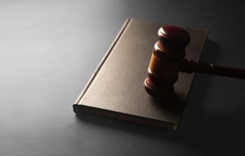 nudify apps ban - A wooden gavel rests on a closed book.