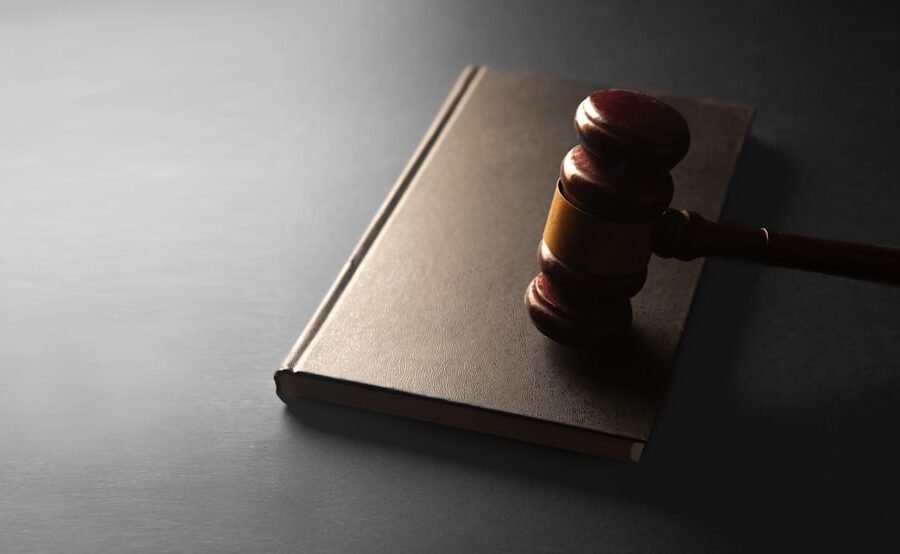 nudify apps ban - A wooden gavel rests on a closed book.