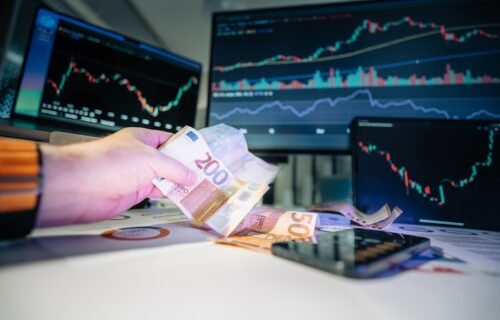 chip stock weakness - A person holding money in front of a computer screen