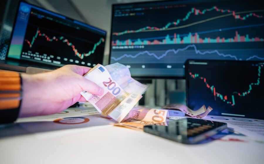 chip stock weakness - A person holding money in front of a computer screen