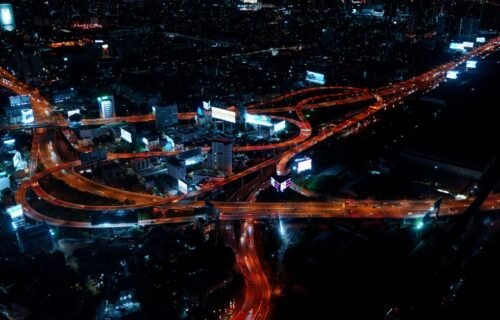 real-time payments asia-pacific - Aerial view of Bangkok's vibrant city lights and roads at night.