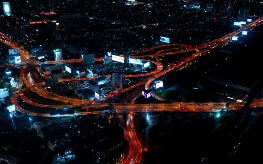 real-time payments asia-pacific - Aerial view of Bangkok's vibrant city lights and roads at night.