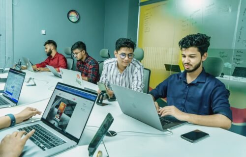cap table startup - a group of people sitting around a table with laptops