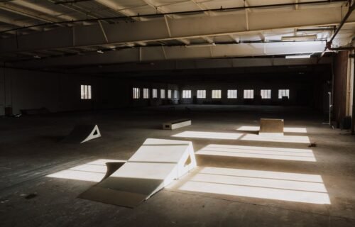 ramp valuation - Sunlight casting shadows over ramps in an empty indoor skate park.