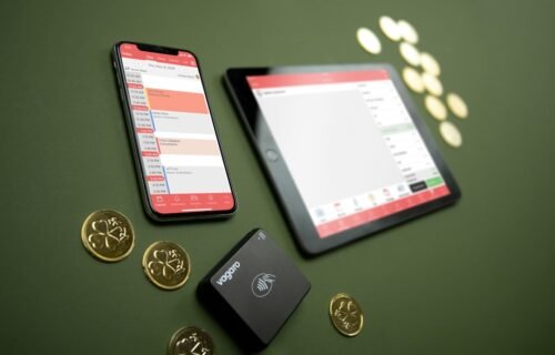 payment acceptance - Smartphone, tablet, payment terminal, and coins on table